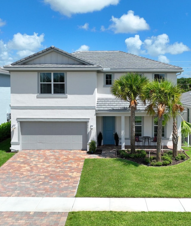 view of front of property featuring a front yard, a garage, and a porch