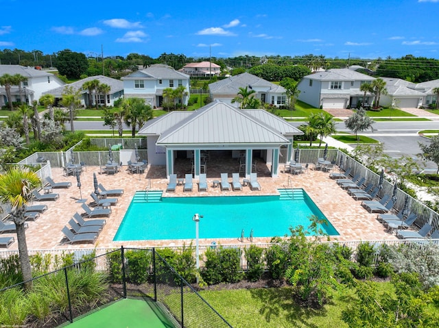 pool featuring a patio, fence, and a residential view