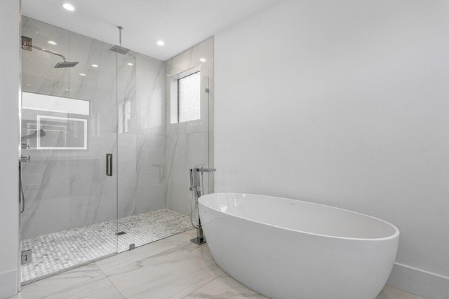 bathroom with recessed lighting, a freestanding tub, marble finish floor, and a marble finish shower