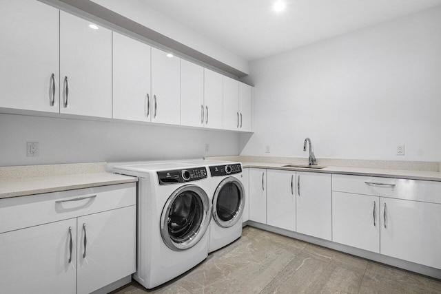 laundry room with washer and dryer, cabinet space, and a sink