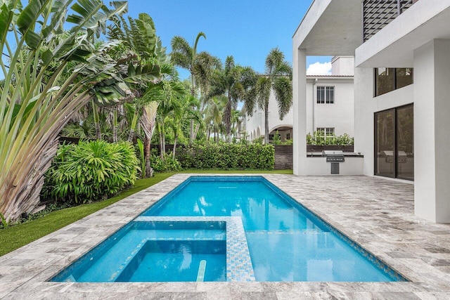 view of pool with a pool with connected hot tub, exterior kitchen, and a patio