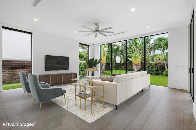 living room with a wealth of natural light, a wall of windows, and ceiling fan