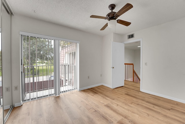 unfurnished room featuring a textured ceiling, ceiling fan, and light wood-type flooring