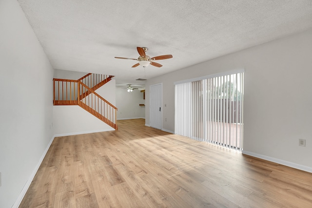 unfurnished living room with ceiling fan, light hardwood / wood-style flooring, and a textured ceiling