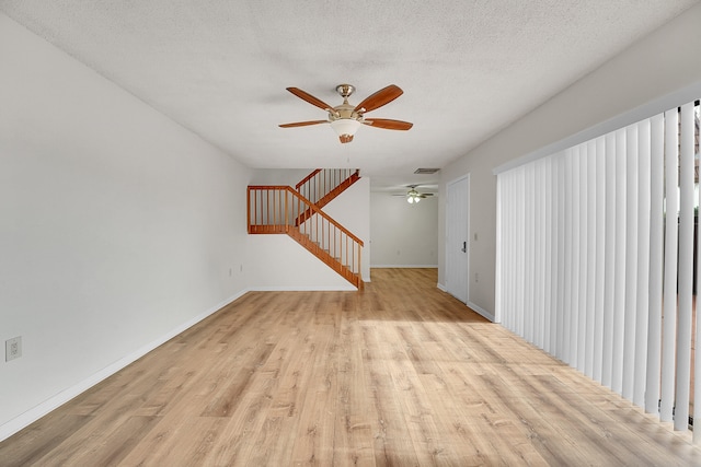 unfurnished room featuring a textured ceiling, light hardwood / wood-style flooring, and ceiling fan