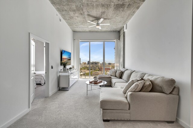 living room with carpet, a ceiling fan, and baseboards