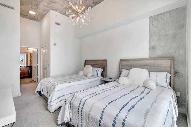 carpeted bedroom with connected bathroom and an inviting chandelier