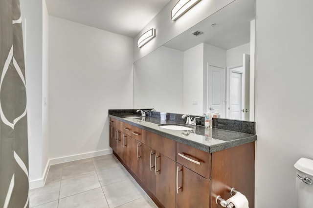 full bath featuring tile patterned floors, toilet, baseboards, and a sink