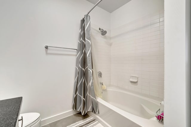 bathroom with toilet, baseboards, and shower / bath combo with shower curtain