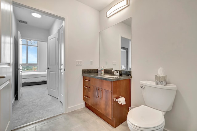 bathroom featuring tile patterned flooring, toilet, and vanity