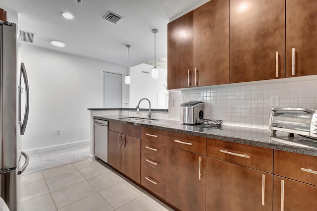 kitchen featuring a sink, visible vents, backsplash, and stainless steel appliances