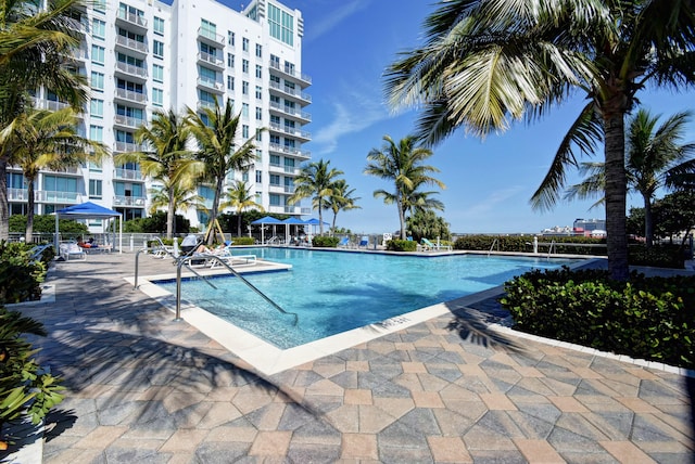 community pool with a patio and fence