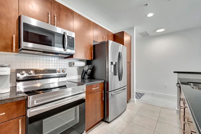 kitchen featuring light carpet, decorative backsplash, and stainless steel appliances