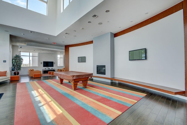 rec room with dark hardwood / wood-style flooring, pool table, and a towering ceiling