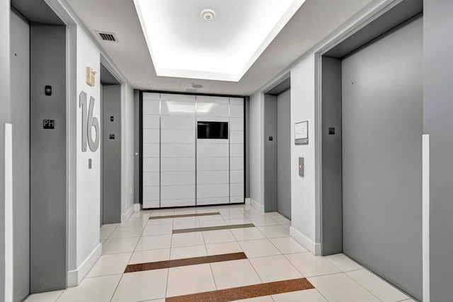 hall with elevator and light tile patterned floors