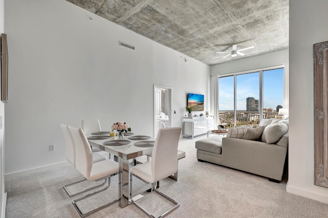 carpeted dining room with ceiling fan