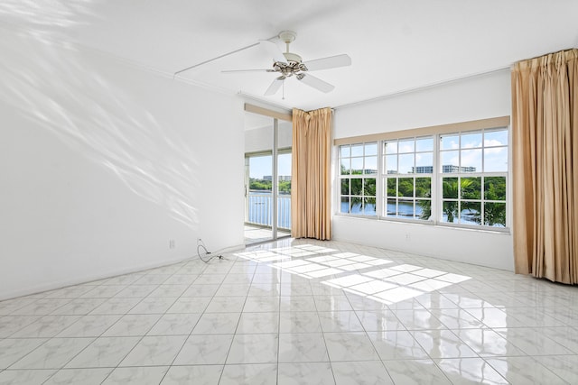 empty room with crown molding, a water view, and ceiling fan