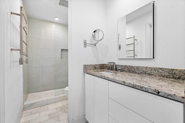 bathroom featuring toilet, tile patterned floors, vanity, radiator heating unit, and a shower with shower door