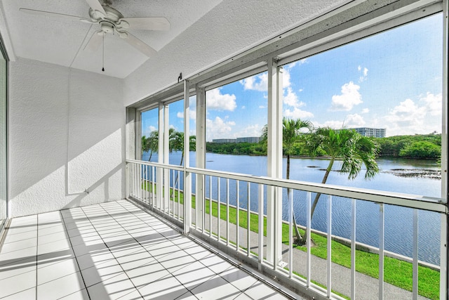 balcony with ceiling fan and a water view