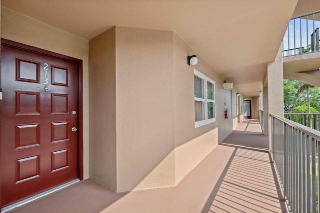 property entrance featuring a balcony and stucco siding