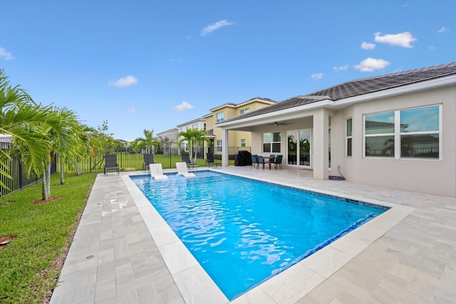 view of swimming pool with ceiling fan, grilling area, and a patio