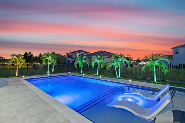 pool at dusk with a patio area