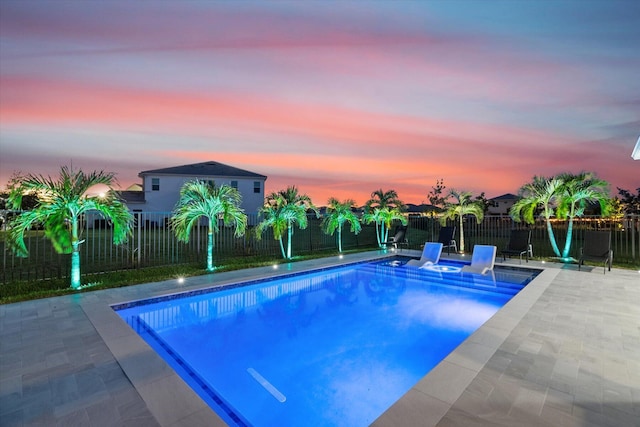 pool at dusk with a patio