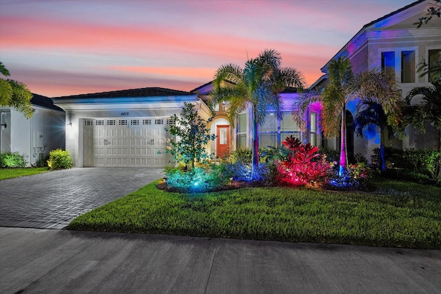 view of front of home featuring a garage and a yard