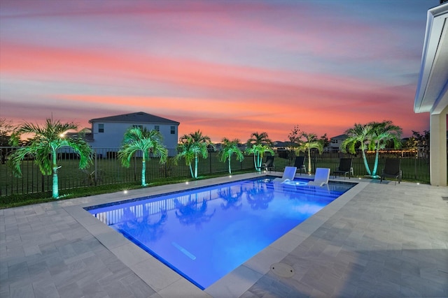 pool at dusk with a patio