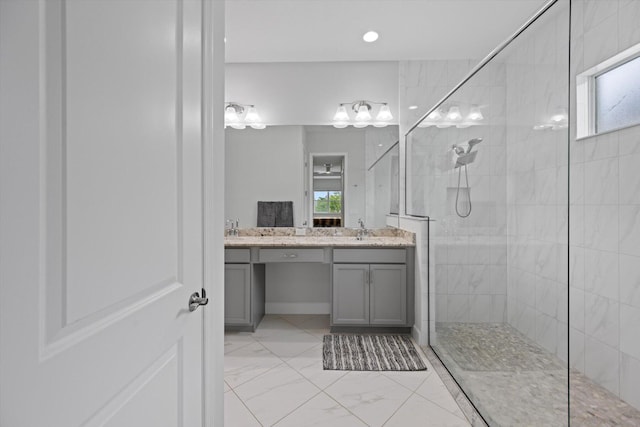 bathroom with tiled shower and vanity