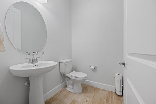 bathroom with toilet and hardwood / wood-style floors