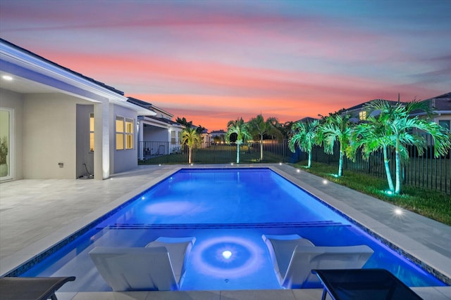 pool at dusk with a patio