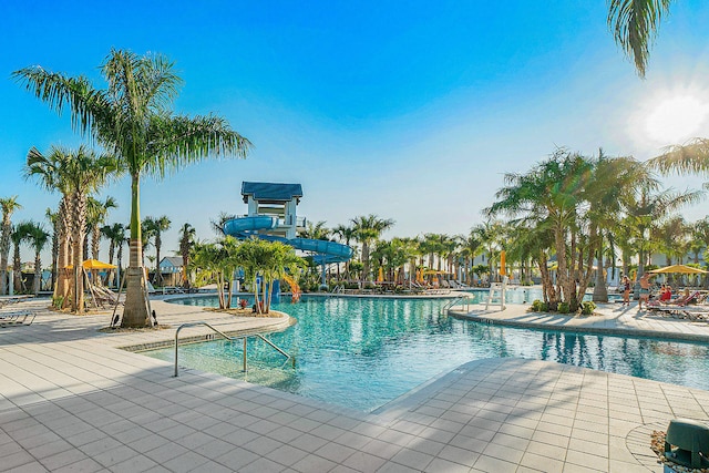 view of pool with a water slide and a patio