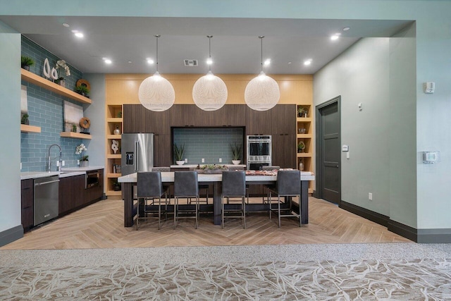 kitchen with built in features, appliances with stainless steel finishes, and light parquet floors