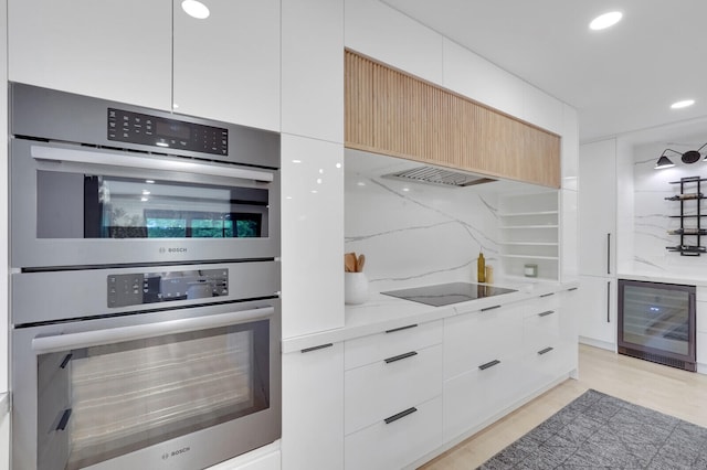 kitchen featuring light wood-type flooring, double oven, and white cabinetry