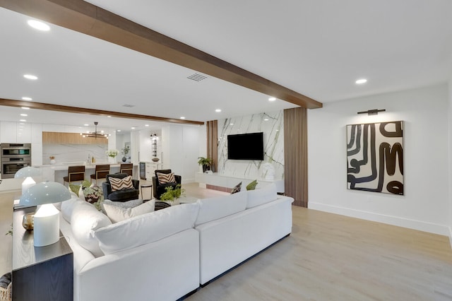 living room featuring light wood-type flooring and beamed ceiling