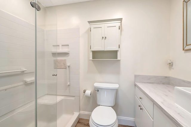 bathroom with wood-type flooring, an enclosed shower, vanity, and toilet