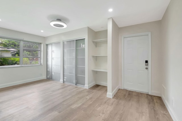 interior space featuring light hardwood / wood-style flooring and two closets