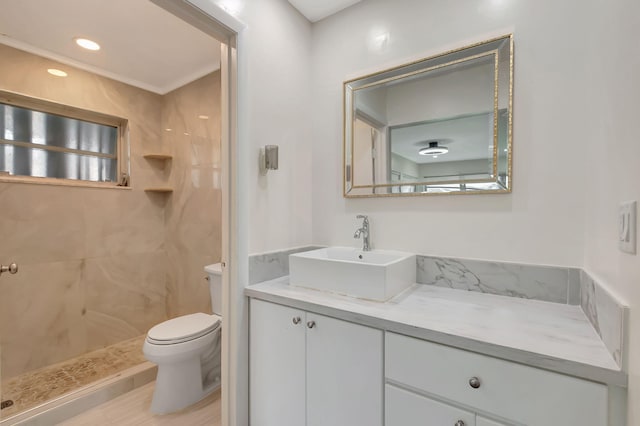 bathroom with tiled shower, toilet, and vanity