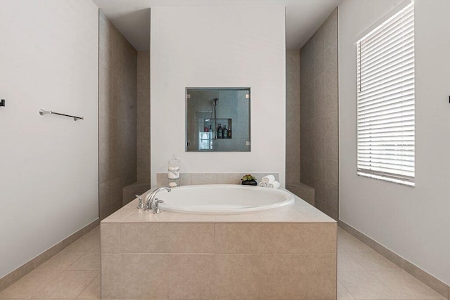 bathroom with tile patterned flooring and tiled tub