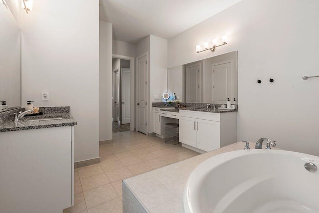 bathroom with tile patterned flooring, a bathtub, and vanity