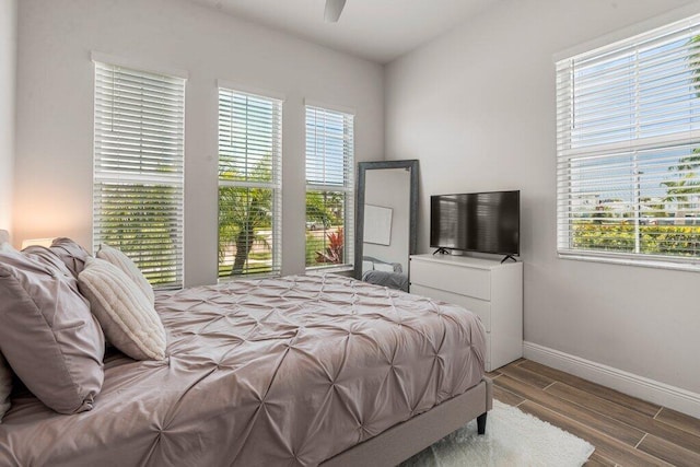 bedroom with multiple windows, hardwood / wood-style floors, and ceiling fan