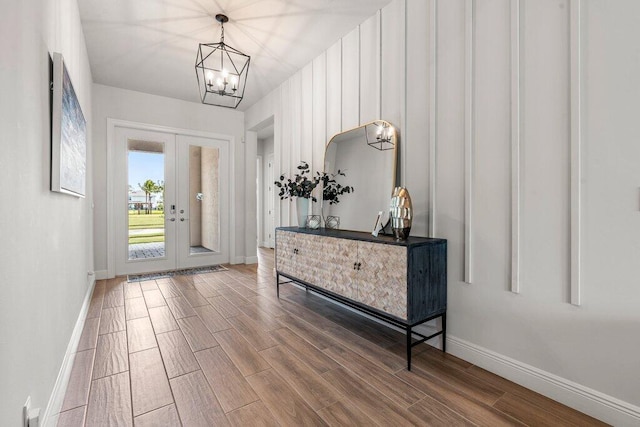 foyer featuring an inviting chandelier, hardwood / wood-style floors, and french doors