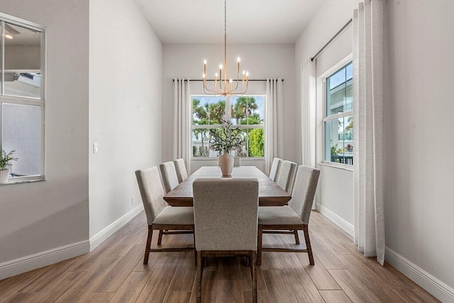 dining area with wood-type flooring and a notable chandelier