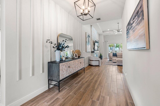 hall featuring hardwood / wood-style floors and an inviting chandelier