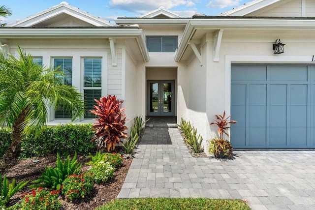 property entrance featuring a garage and french doors