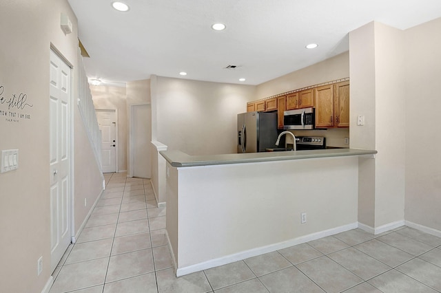 kitchen featuring appliances with stainless steel finishes, sink, and light tile patterned flooring