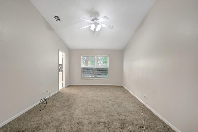 empty room featuring light colored carpet, vaulted ceiling, and ceiling fan