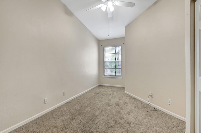 empty room with light colored carpet, ceiling fan, and vaulted ceiling