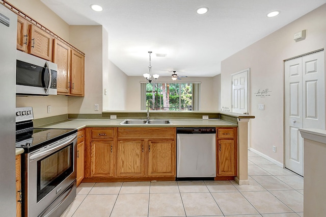 kitchen featuring stainless steel appliances, sink, kitchen peninsula, and light tile patterned flooring